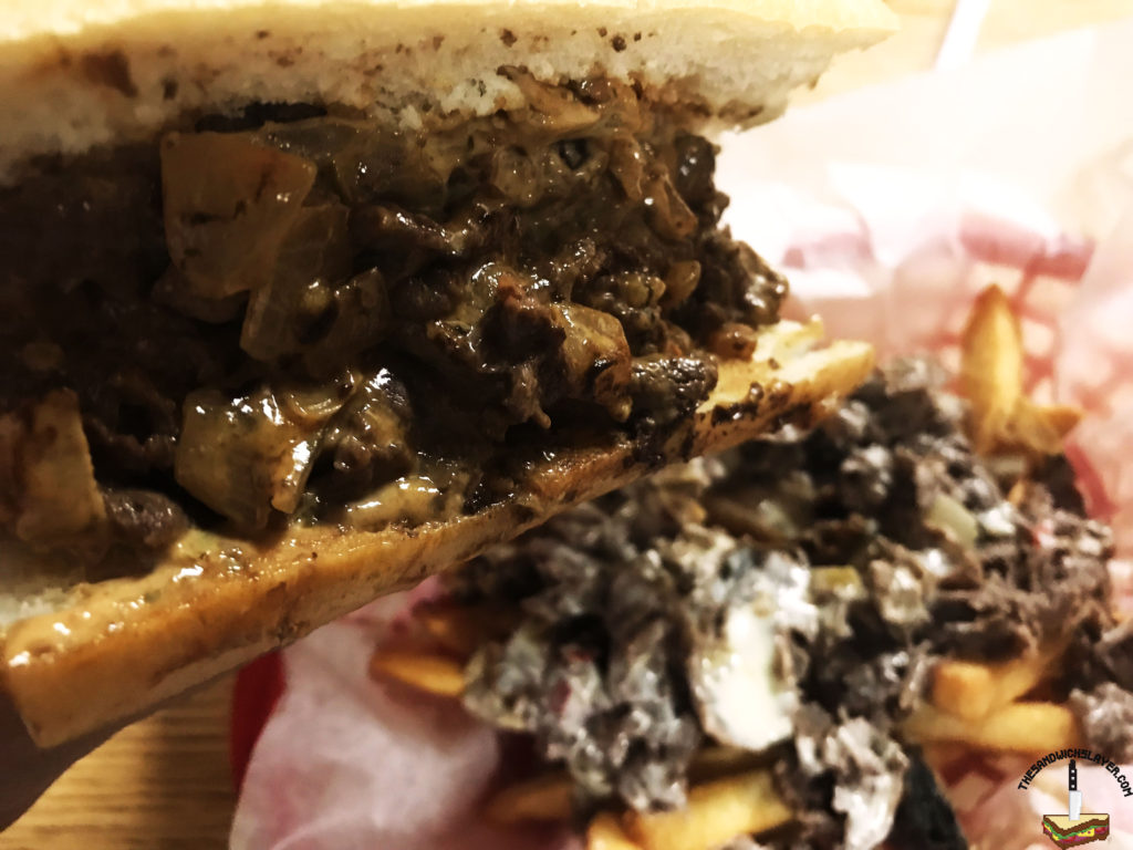 A bite of Jersey 1/2 chipotle cheesesteak with west grove fries