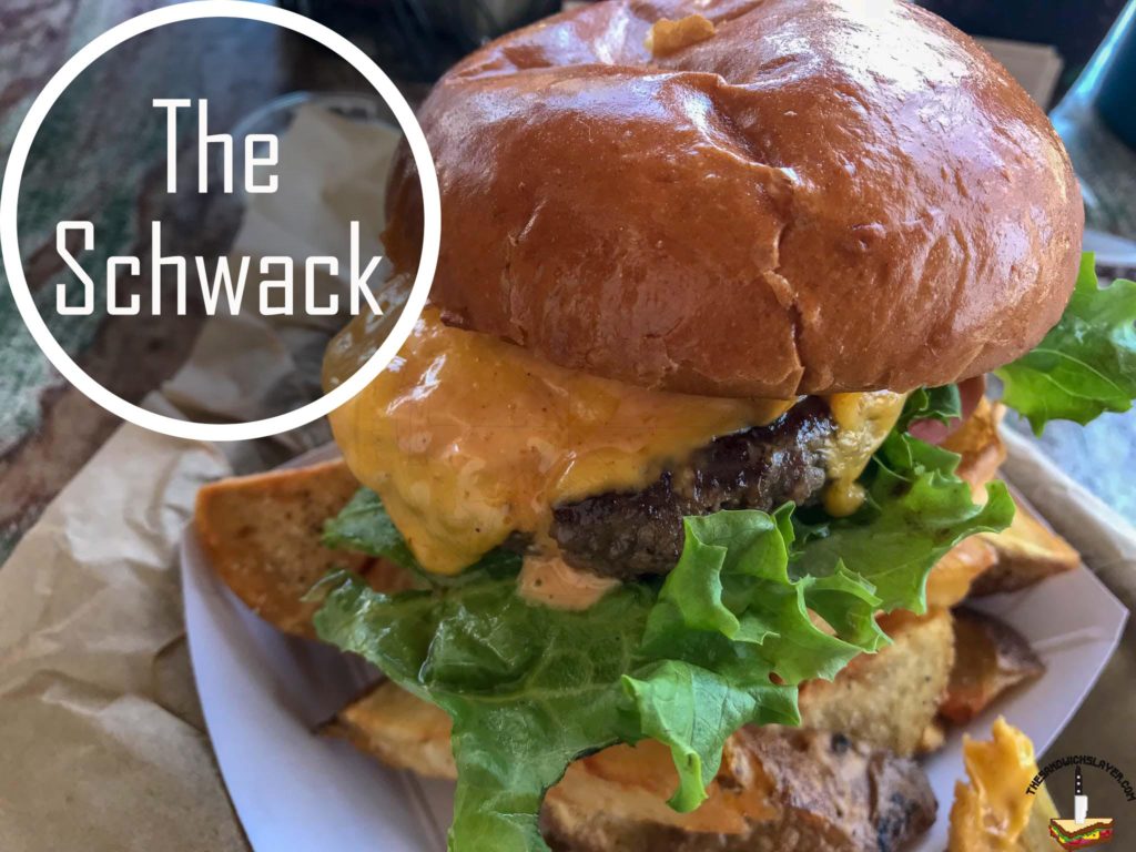 The Schwack Burger with lettuce, tomato, marinated red onion, and schwack sauce